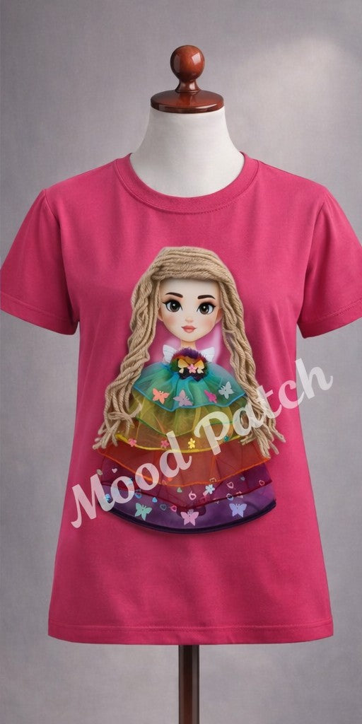 Bring color and creativity to your little one’s wardrobe with the Mood Patch T-shirt — a playful blend of comfort and artistry. Each shirt features a handcrafted 3D doll patch with braided yarn hair and a layered rainbow tulle dress adorned with butterflies and flowers.

Perfect for casual outings, birthdays, or gifting, this design celebrates individuality and joy. Available in white, lilac, and dark pink, each piece is made from breathable cotton for all-day comfort.